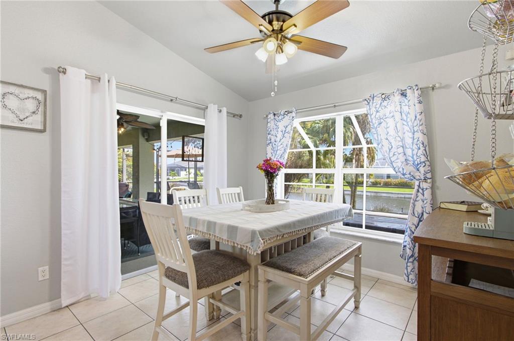 Dining area with vaulted ceiling, ceiling fan, and tile flooring