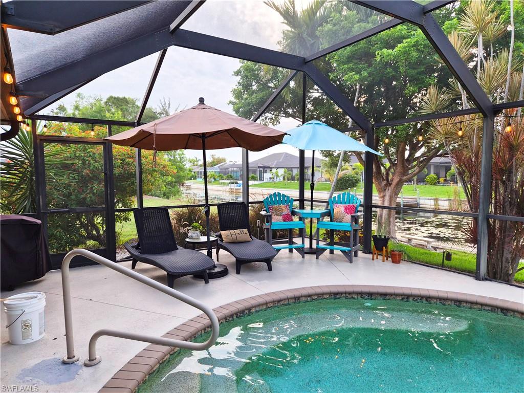 Screened outdoor living area featuring a circular spa with coping and handrail