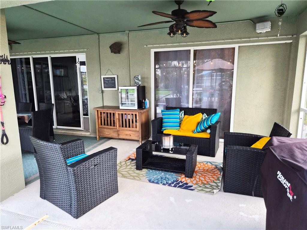 Expansive covered patio featuring a ceiling fan, concrete flooring, and sliding glass doors
