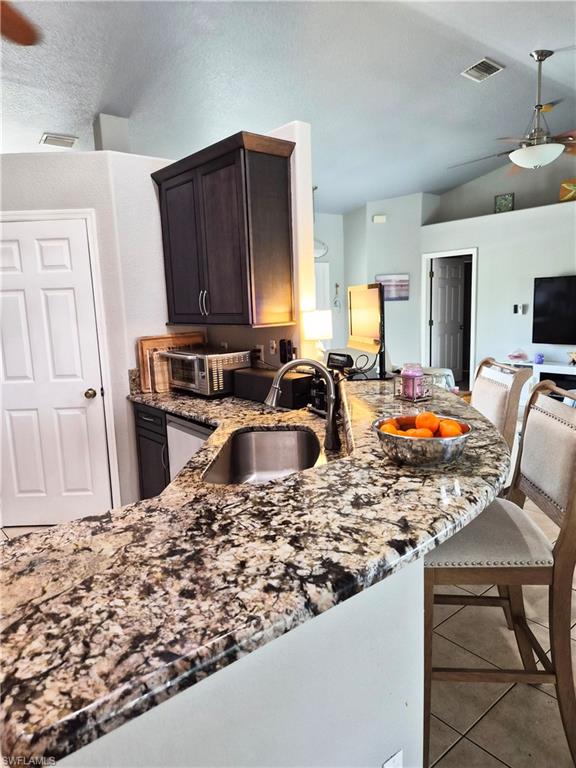 Curved countertop with an undermount sink and a high-arch faucet, featuring dark wood-finish cabinetry