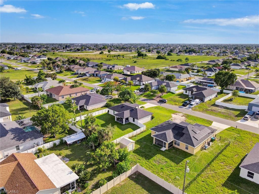 Aerial overview of a residential area featuring multiple single-story homes, many with private fencing and landscaping