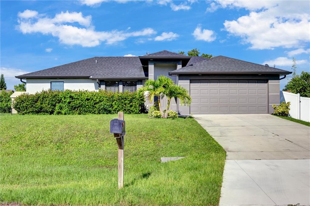 Contemporary stucco exterior featuring a dark asphalt shingle roof and an integrated two-car garage