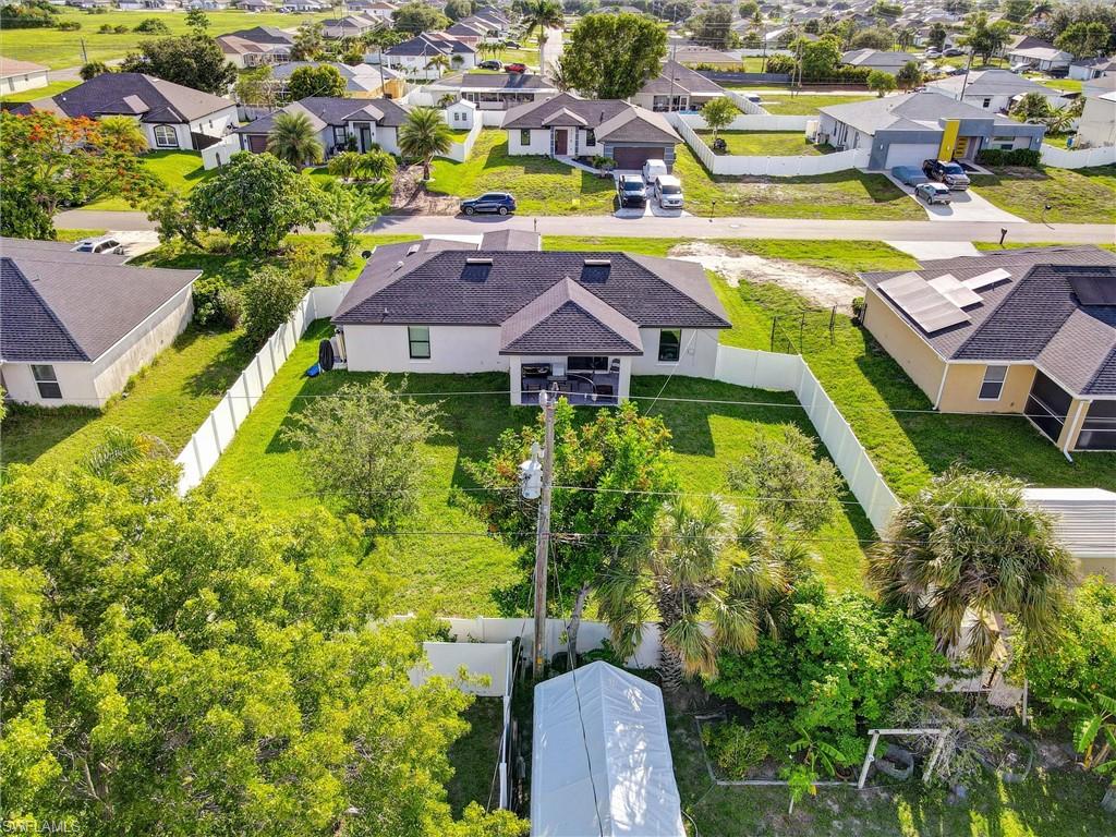 Single-story residence featuring a dark shingle roof, white exterior siding, and a rear balcony
