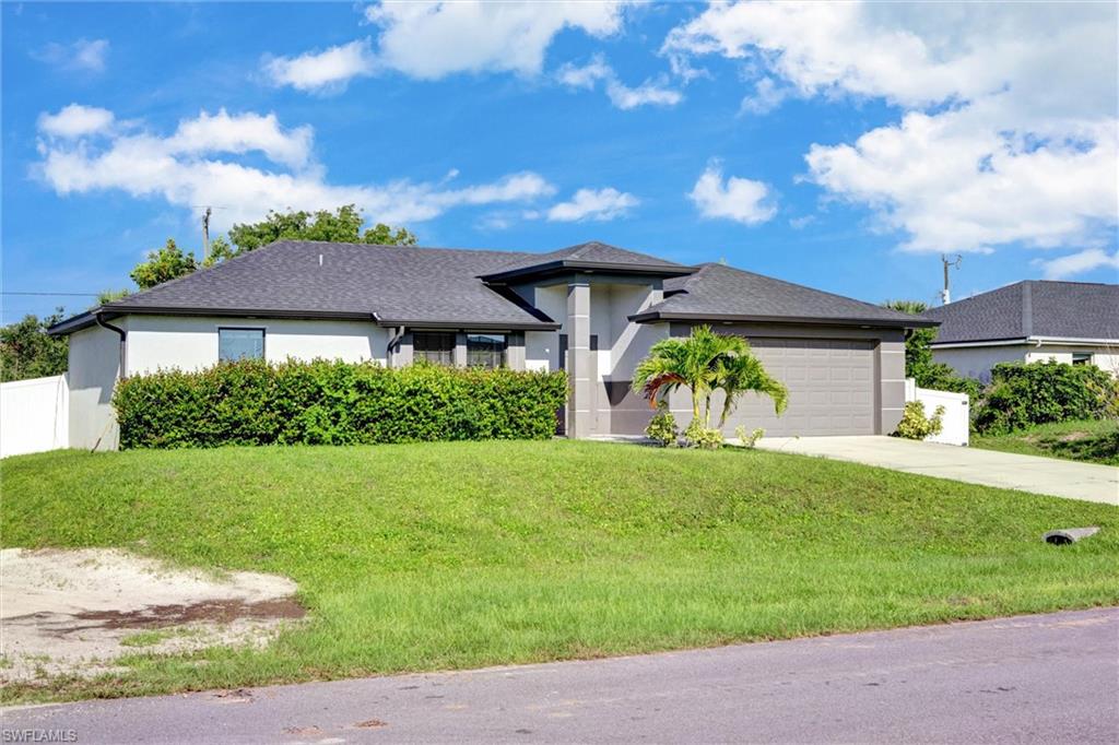 Contemporary stucco exterior with a dark shingle roof, featuring an integrated two-car garage