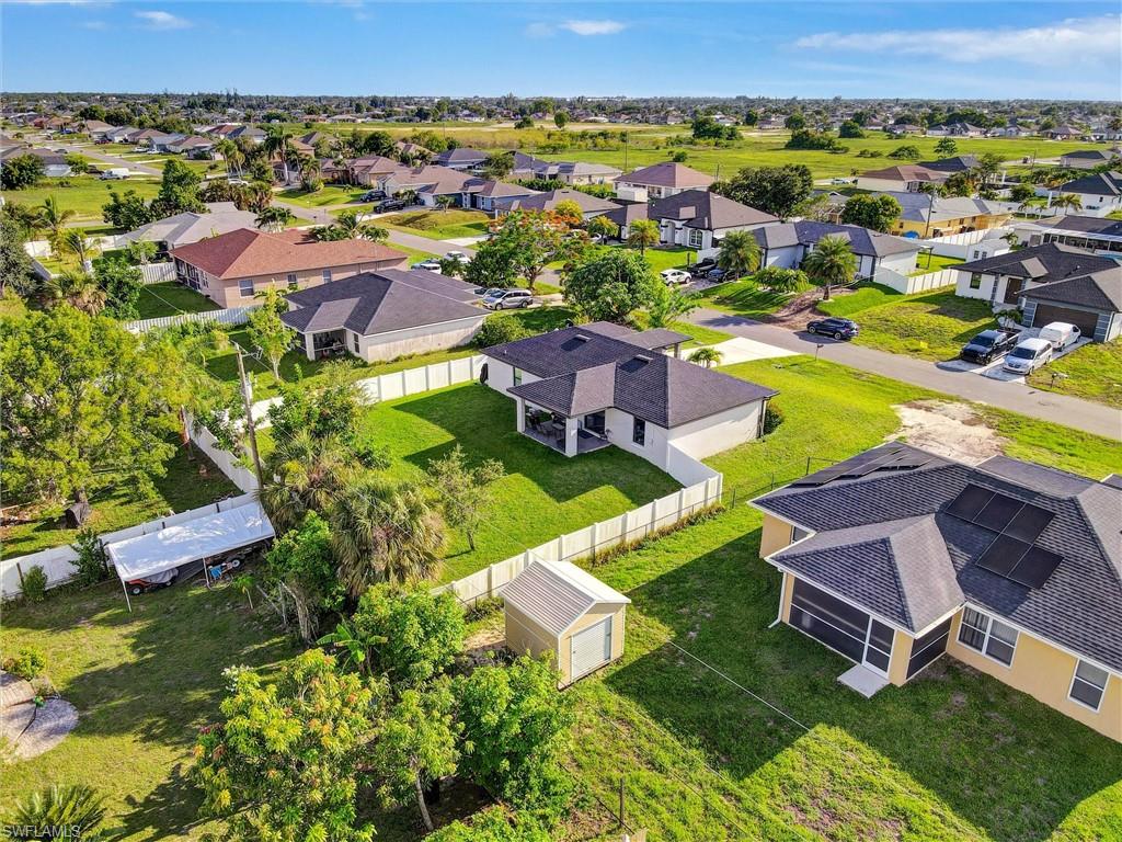 Aerial perspective showcasing a residential neighborhood with single-story homes, many featuring dark shingle roofs and light-colored exteriors