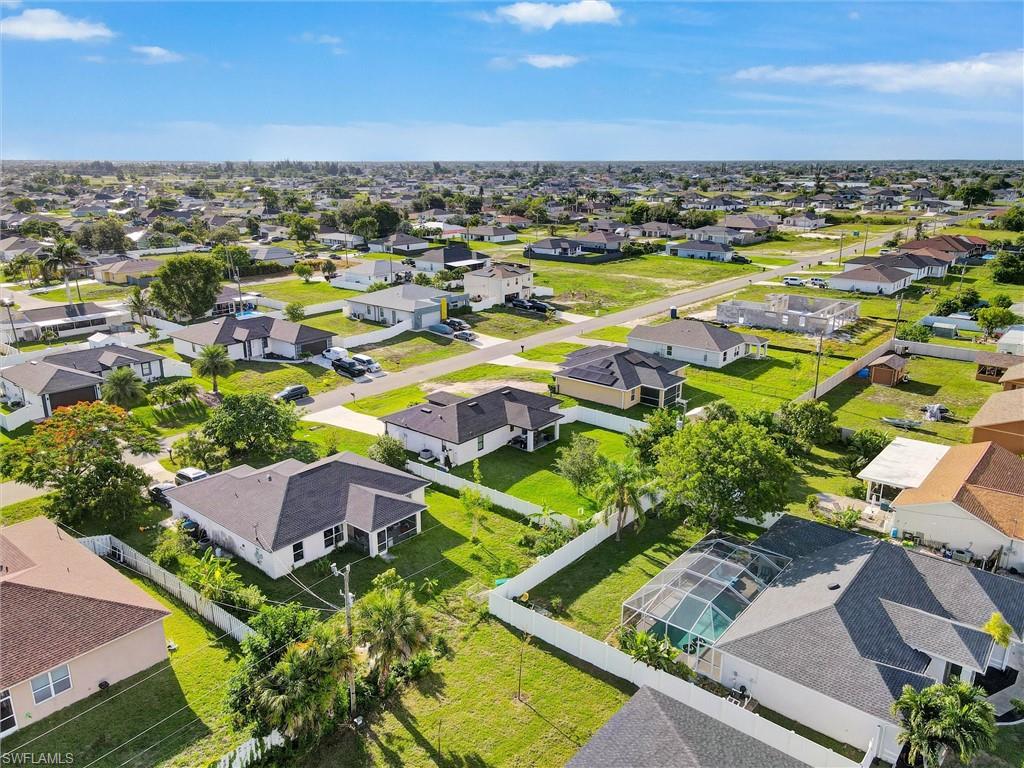 Aerial perspective showcasing a residential area with single-story homes and undeveloped lots