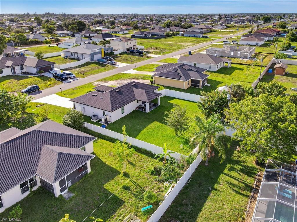 Aerial perspective showcasing residential homes with dark shingle roofs and white or light-colored exteriors