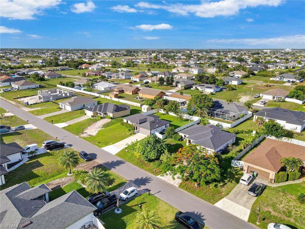 Aerial perspective showcasing a residential neighborhood with single-story homes, many featuring private screened pools