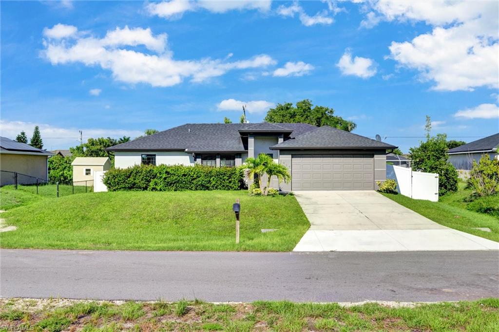 Contemporary stucco home featuring a dark shingle roof, integrated two-car garage with a panel door, and a concrete driveway