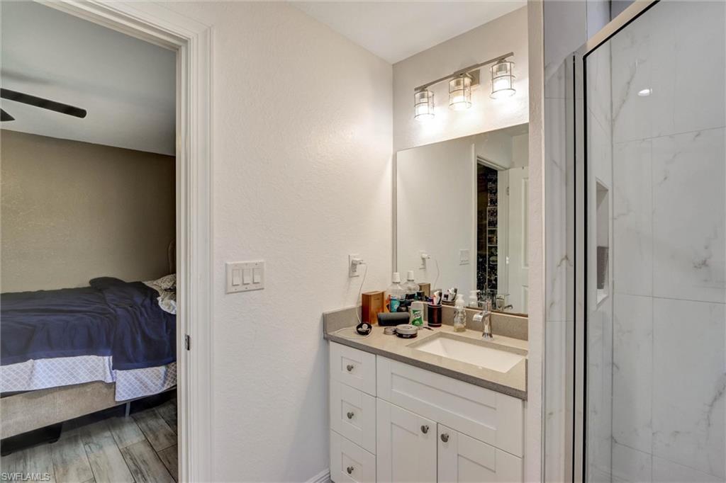 Bathroom vanity featuring an integrated sink, light-colored countertop, and storage cabinetry with brushed nickel hardware