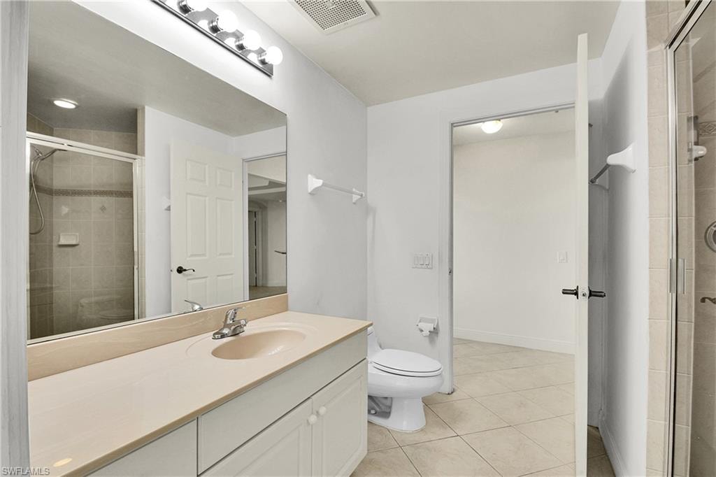 Full bathroom with a stall shower, light tile patterned floors, and vanity