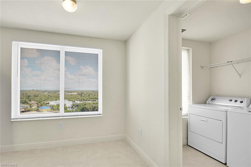 Laundry area featuring washer and dryer and light tile patterned floors