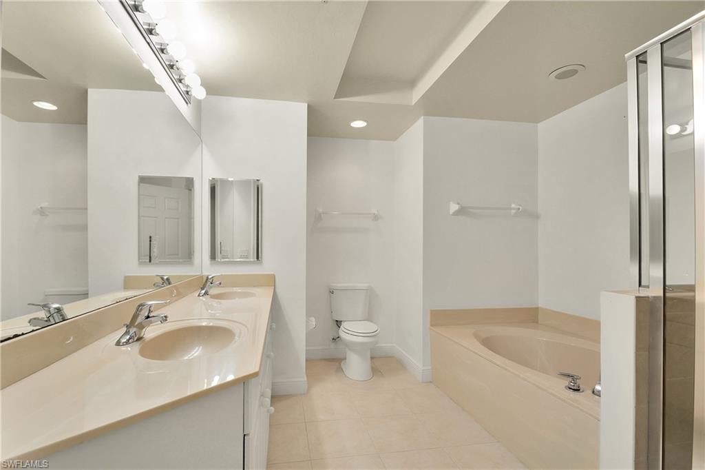 Bathroom featuring a garden tub, a shower stall, double vanity, light tile patterned floors, and recessed lighting
