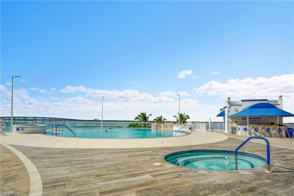 Community pool with a hot tub and a patio area