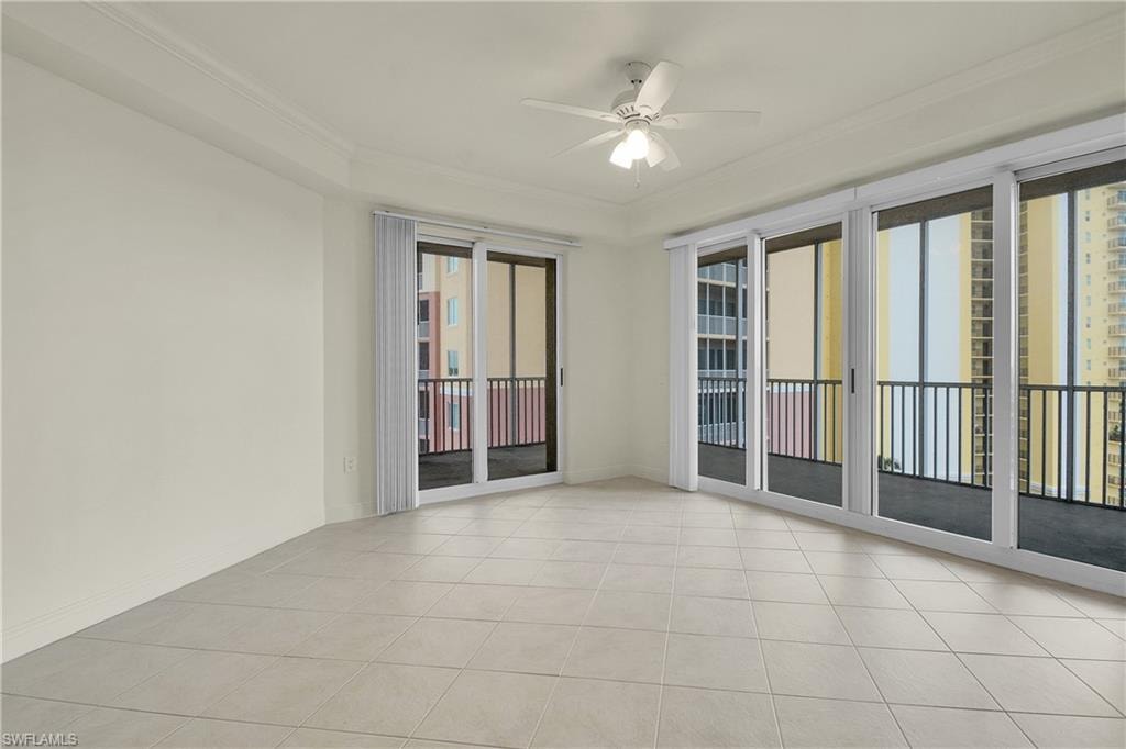Unfurnished room featuring ornamental molding, light tile patterned floors, and a ceiling fan