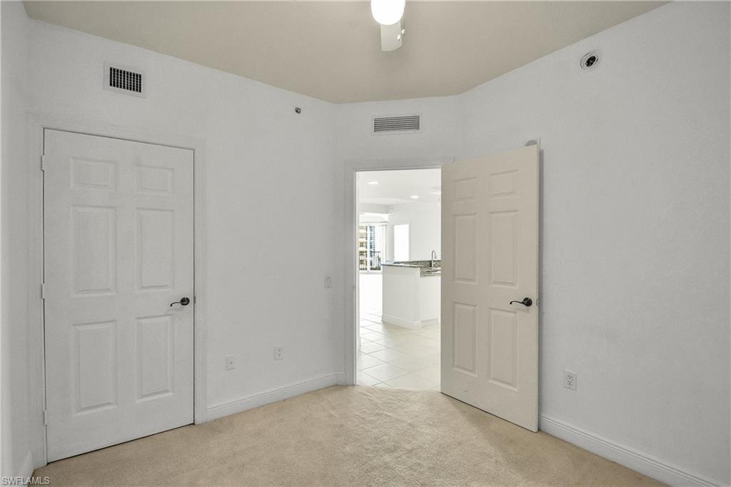 Unfurnished bedroom featuring light carpet and ceiling fan