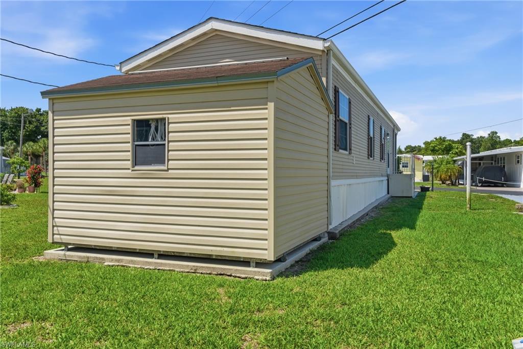 Back of home with storage shed, featuring vinyl siding, a gabled roofline