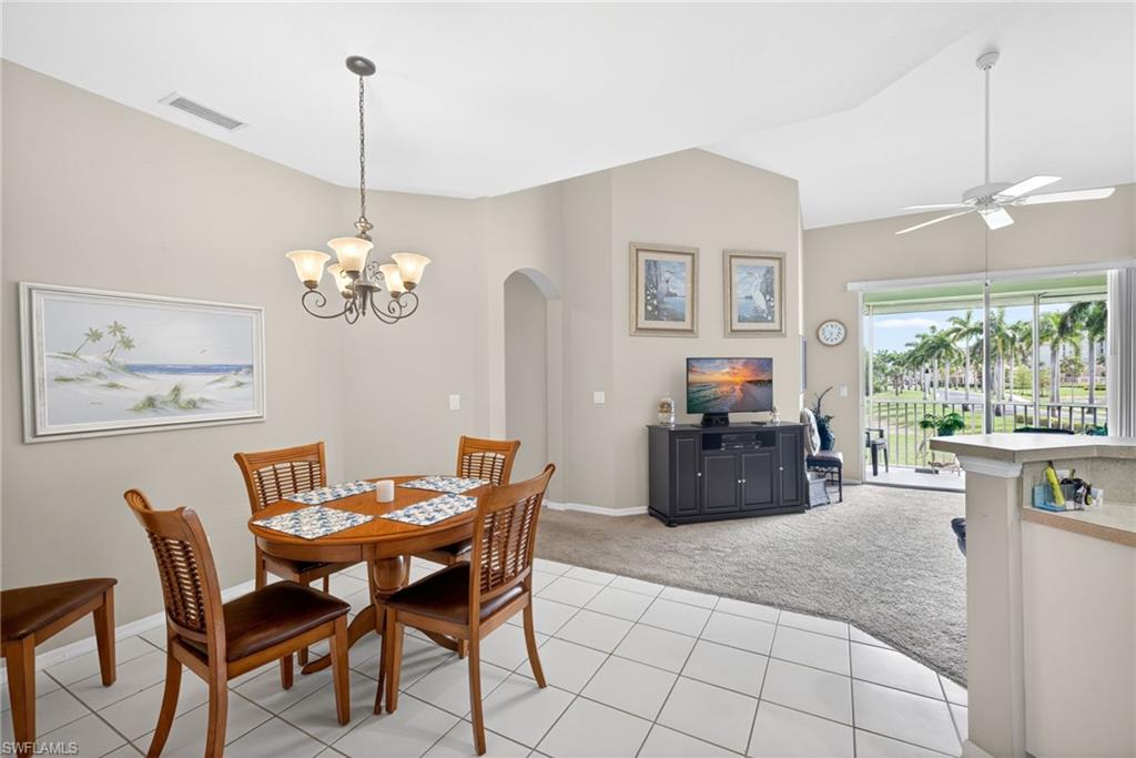 Dining area featuring a decorative chandelier, tile flooring, and an arched entryway
