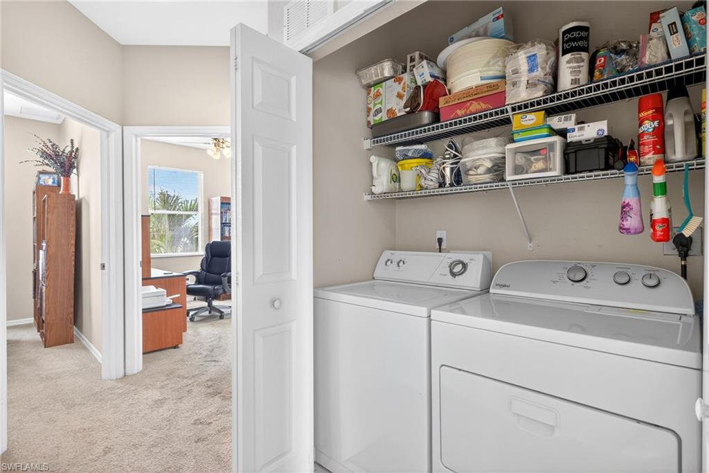 Integrated laundry area featuring a white top-load washing machine and front-load dryer