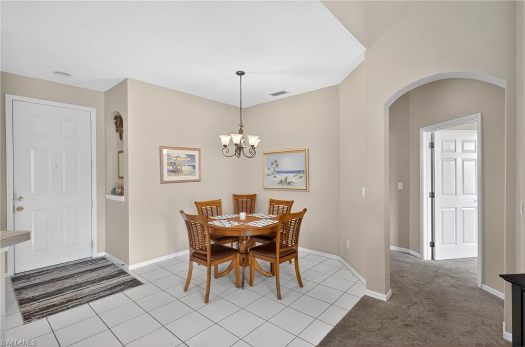 Dining area with tile flooring and a decorative chandelier