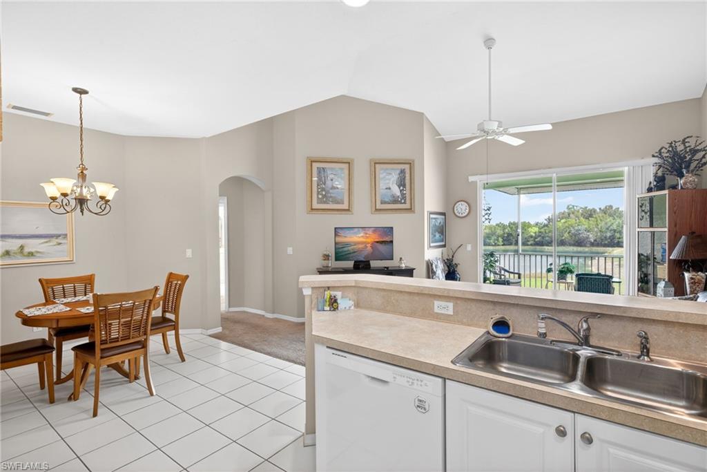 Kitchen featuring white cabinetry, light-toned countertops, and a dual basin stainless steel sink