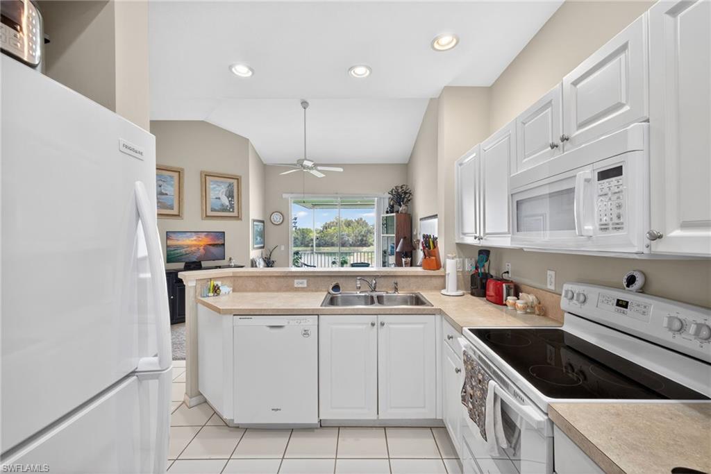 Kitchen featuring white cabinetry, light-toned countertops, and integrated appliances