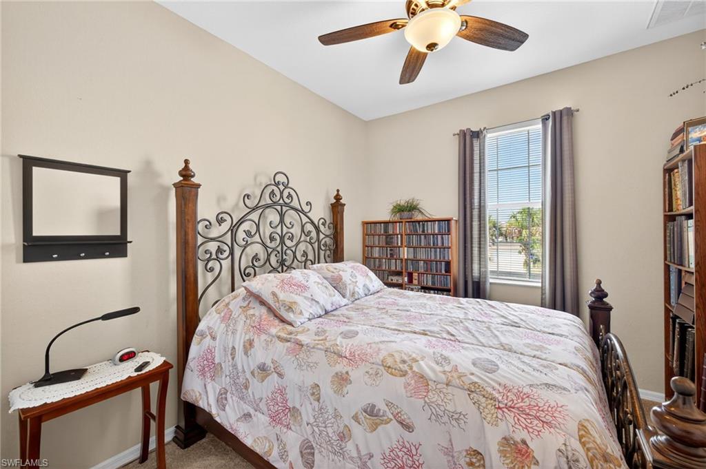 Interior room featuring a ceiling fan with integrated lighting, a window with horizontal blinds and curtains, and neutral wall paint
