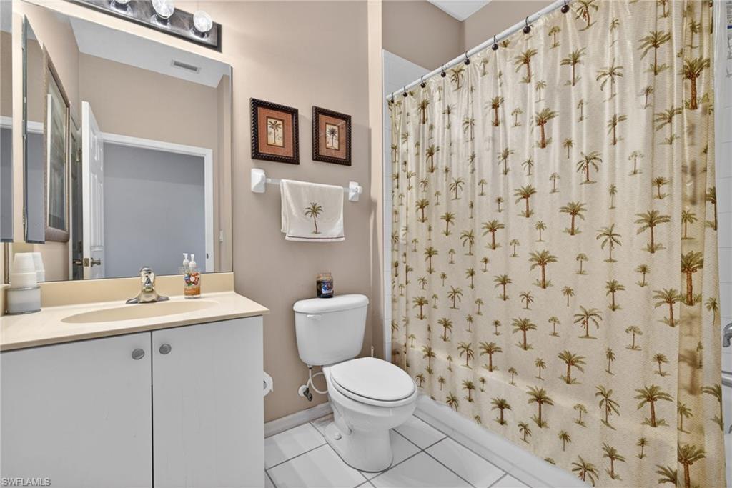 Bathroom featuring a white vanity with integrated sink, rectangular mirror, and wall-mounted light fixture