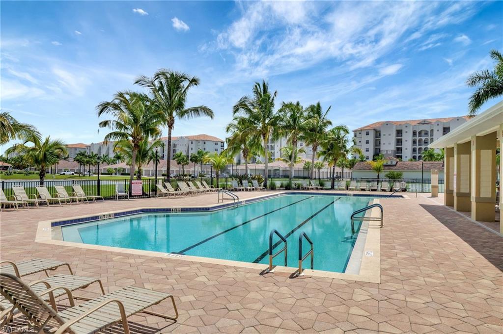 Large swimming pool with lap lanes and integrated entry steps, surrounded by extensive paver decking