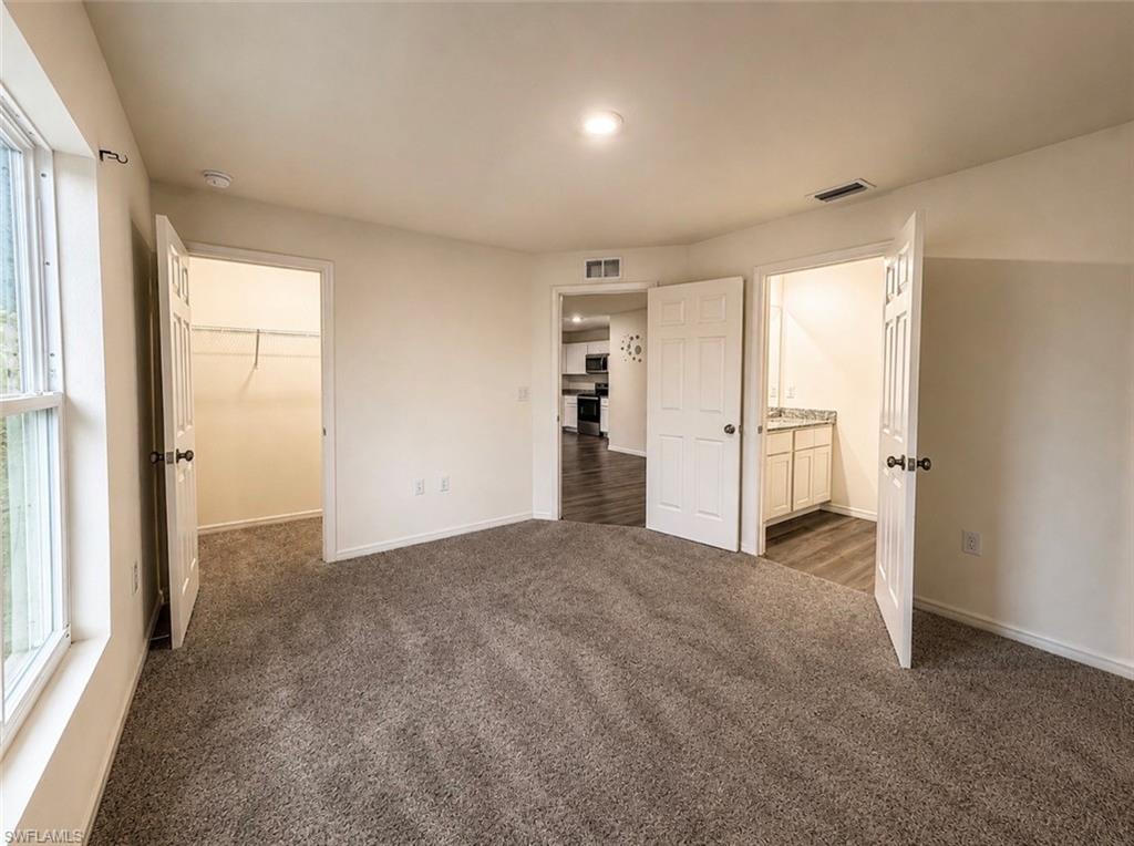 Carpeted room with white walls, recessed lighting, and a white window frame