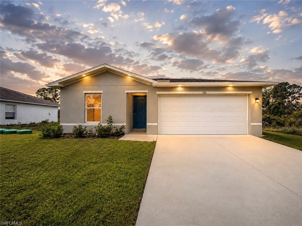 Modern stucco exterior with an attached garage, a contemporary blue entry door, and a concrete driveway