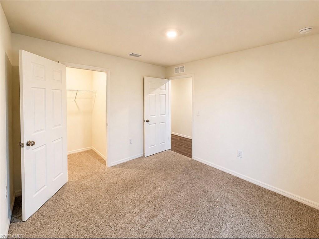 Carpeted room with neutral-toned walls, a recessed ceiling light, and white trim