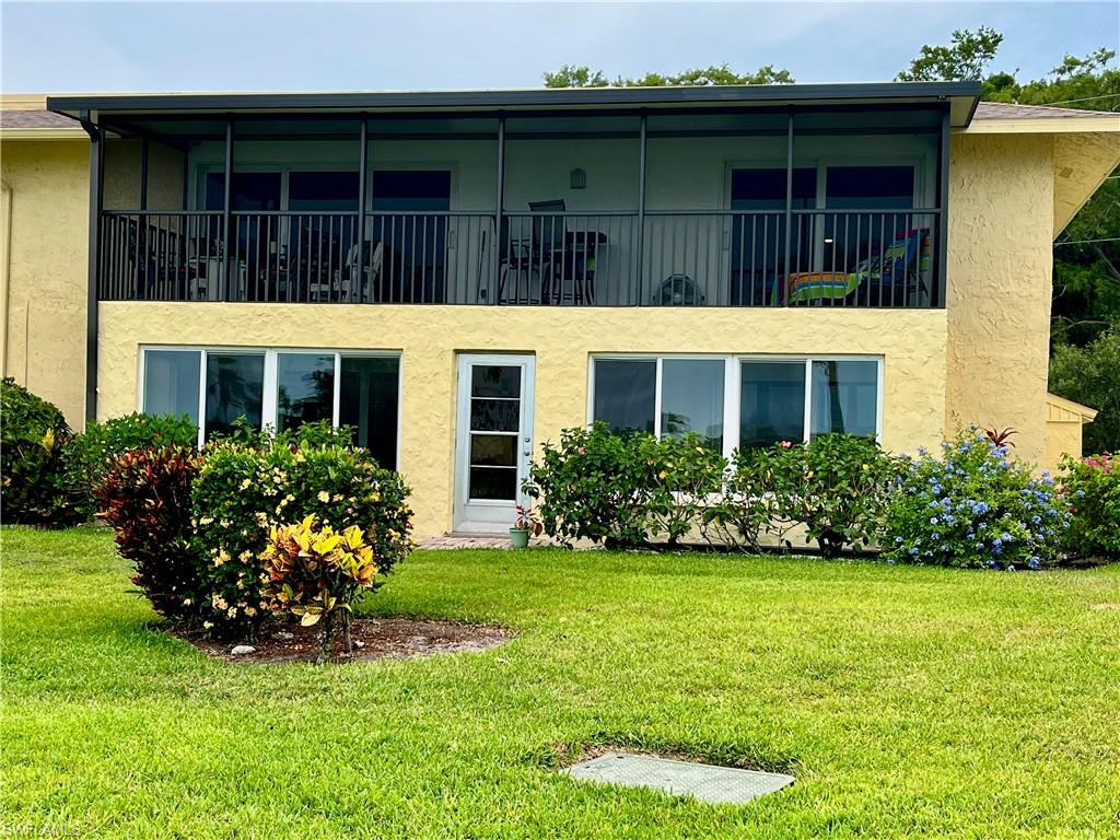 Back of unit from the golf course side - large second floor balcony overlooking grassy area and golf course
