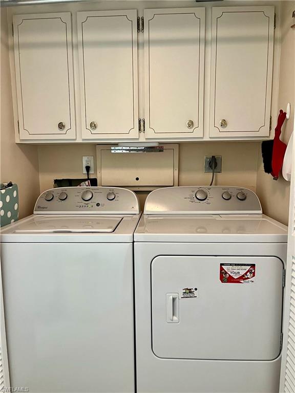 Laundry in residence featuring washing machine and dryer and cabinet space