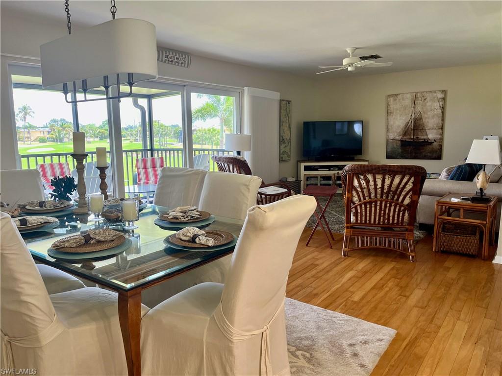 Dining room featuring light hardwood style flooring and a ceiling fan overlooking the golf course.