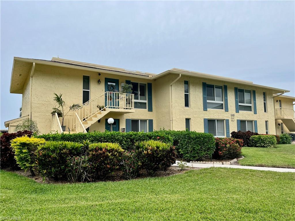 View of building exterior from the parking lot side with entrance on the second floor.