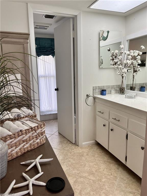 Guest bath featuring single sink vanity, bath and shower