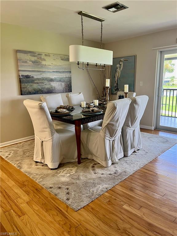 Dining area with Hardwood style floors and baseboards 6 person dining room table for entertaining