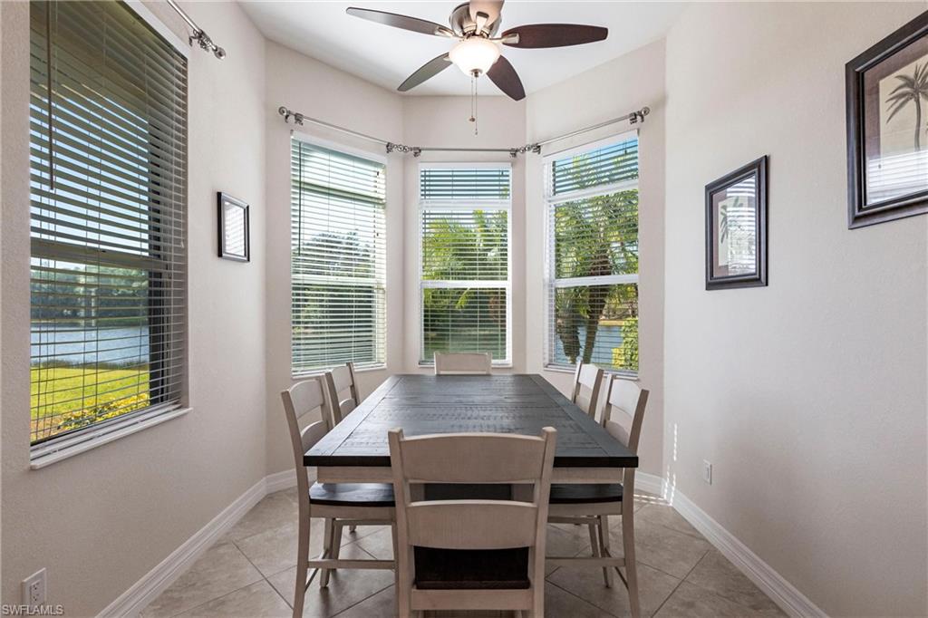 Dining area featuring a bay window with water scenery, recessed lighting, ceiling fan, and tile flooring