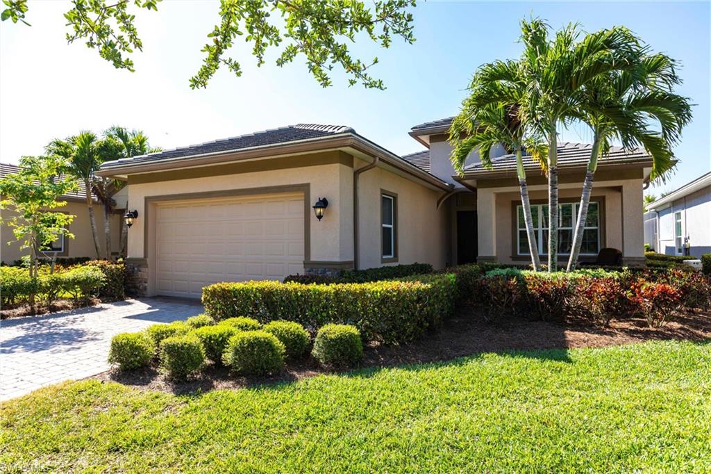 Stucco exterior with a tiled roof and integrated garage