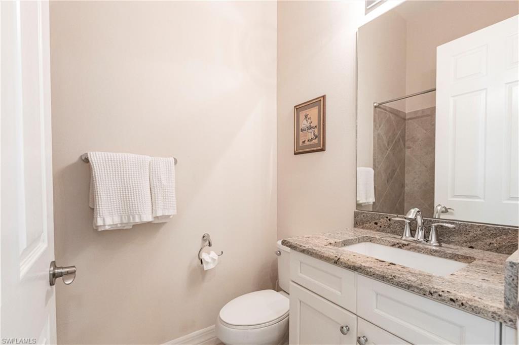 Bathroom featuring a vanity with a granite countertop, undermount sink, and chrome fixtures