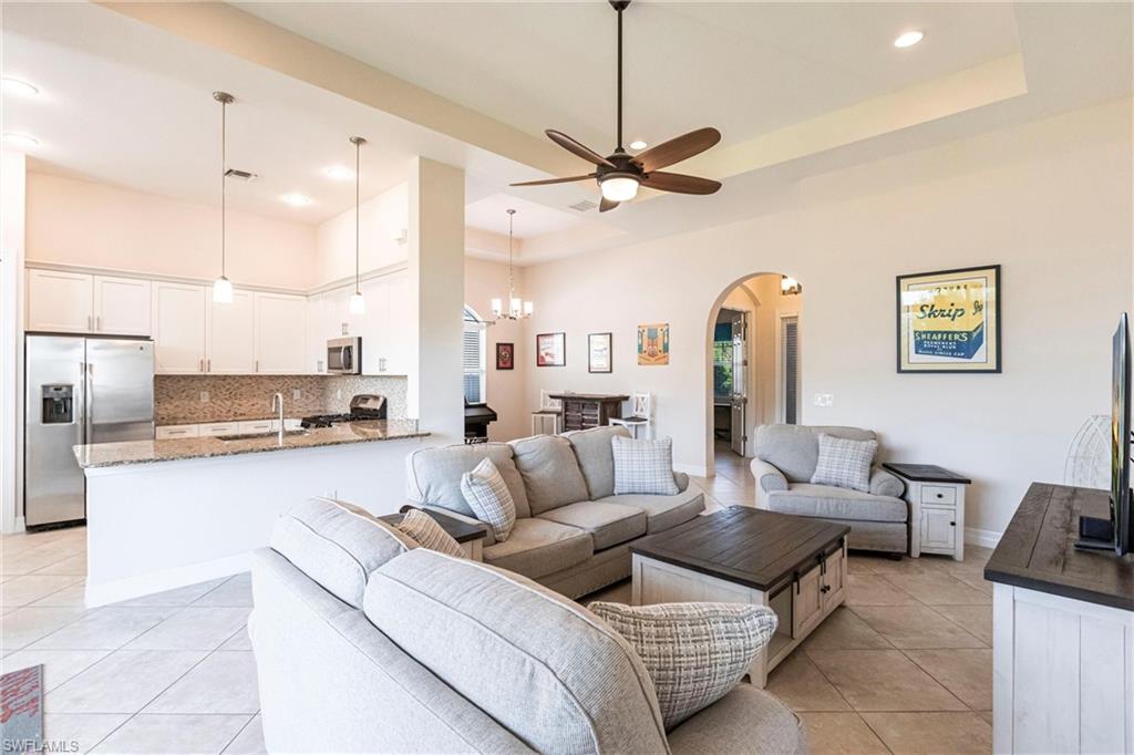 Open-concept living space featuring a kitchen with stainless steel appliances, a breakfast bar, and pendant lighting