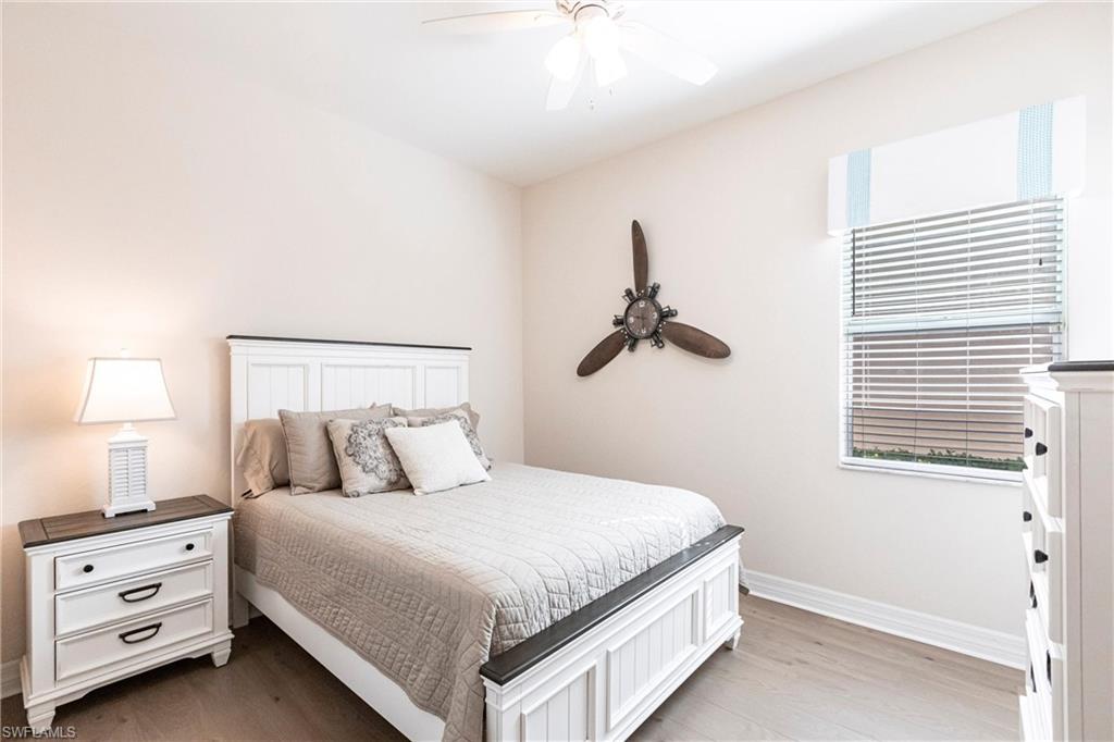 Bedroom featuring wood-finish flooring, a window with blinds, a ceiling fan, and light-toned walls