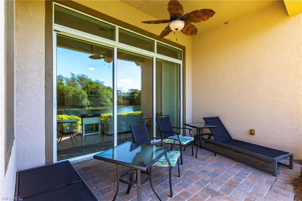Patio featuring brick paver flooring, a ceiling fan, and sliding glass doors