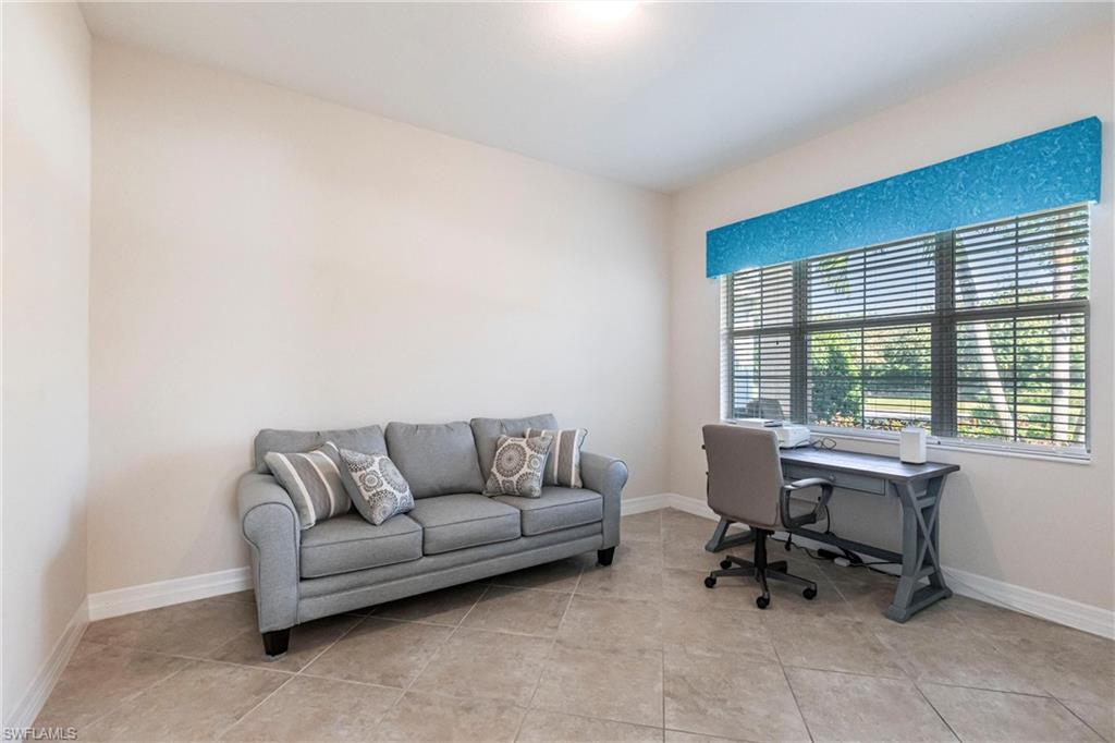 Spacious room featuring neutral wall tones, large window with horizontal blinds, and tile flooring