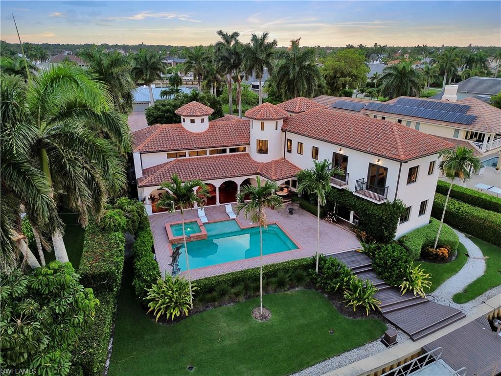 Mediterranean-style residence featuring a terracotta tile roof, multiple balconies with dark railings, and a prominent tower