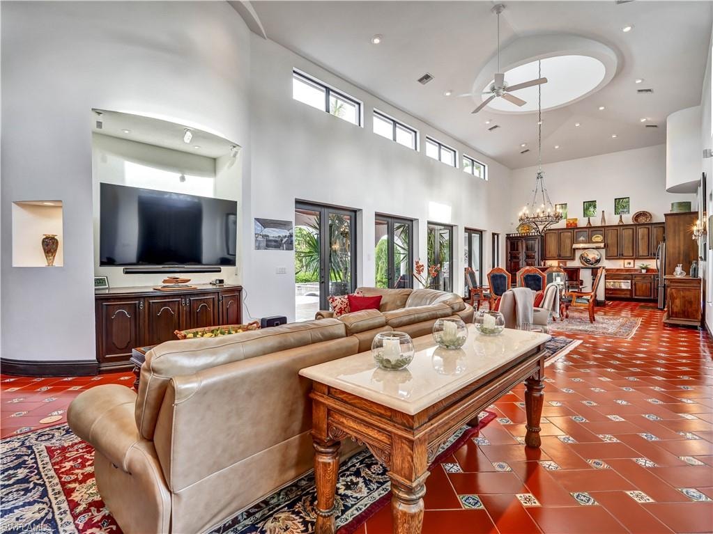 Living area featuring high ceilings, a circular ceiling detail with a fan, and clerestory windows