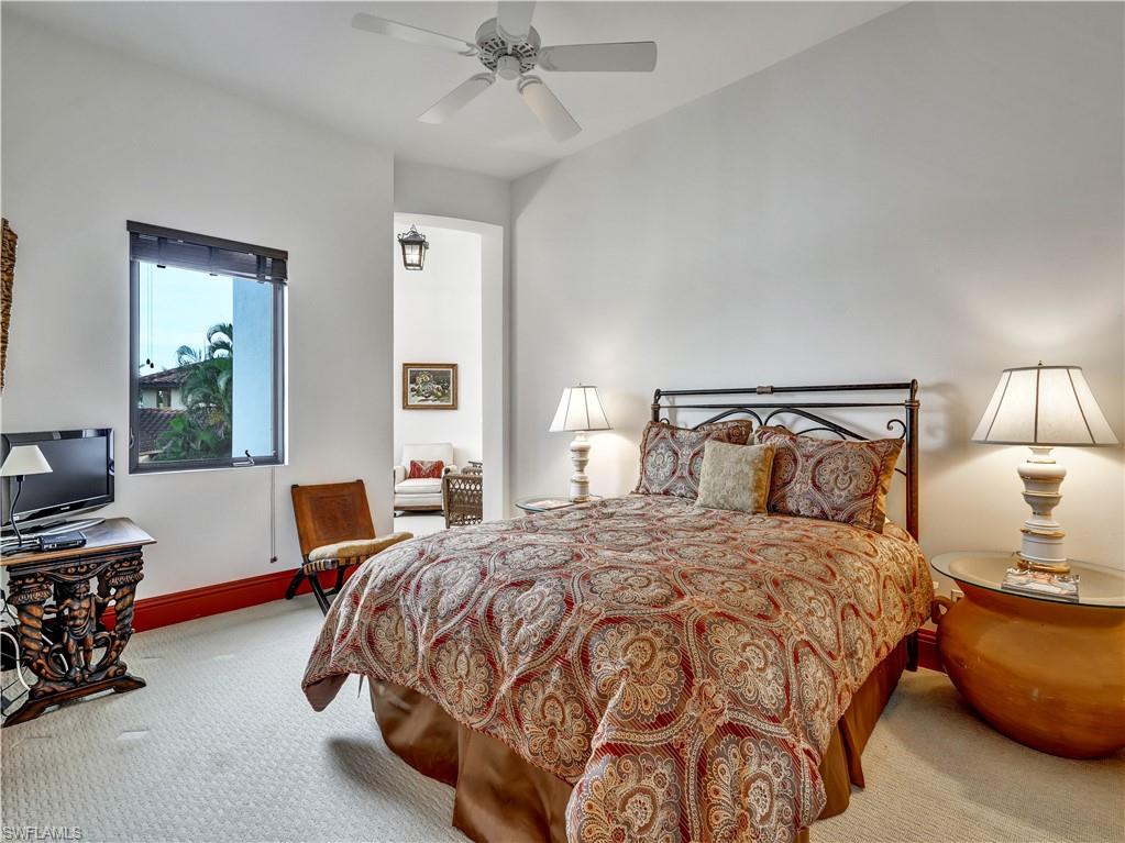 Bedroom featuring a window with exterior landscaping, a ceiling fan, and carpeted flooring