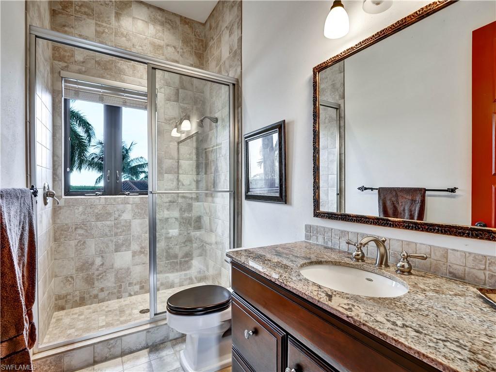 Walk-in shower with glass enclosure and light-toned tile surround
