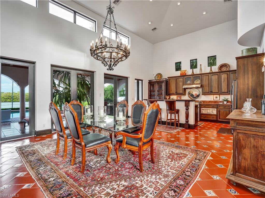 Formal dining space featuring terracotta tile flooring and a grand chandelier